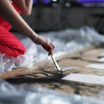 Zdjęcie z Akcja miejska Schultz Perfomance. Na zdjęciu znajduje się uczestnik zajęć malujący na szarym papierze.