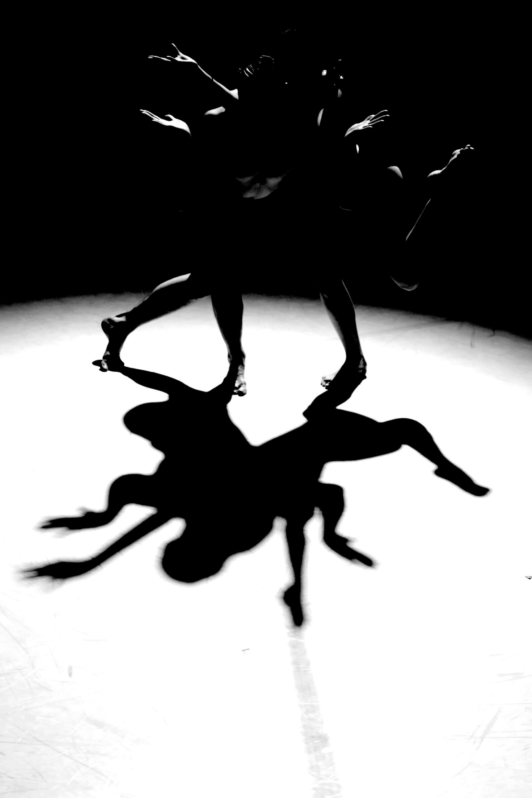 Zdjęcie Illumination. Zdjęcie czarno-białe. Na zdjęciu znajdują się dwie osoby, które wyginają się w różne strony.